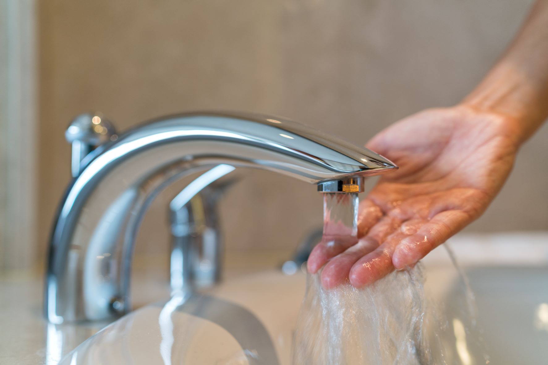 A person is washing their hand in a sink.
